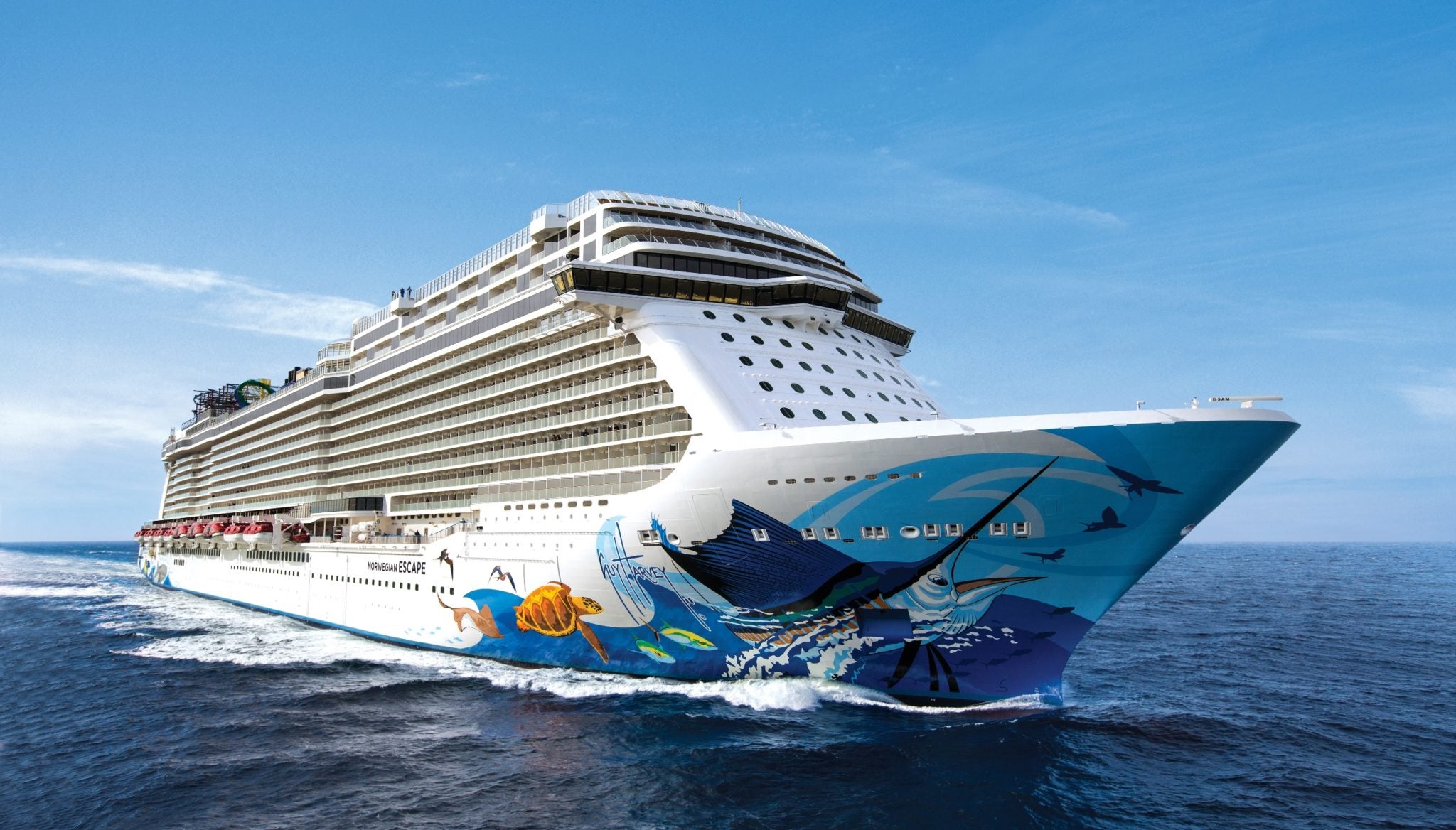 Norwegian Escape sailing at sea, showing the Guy Harvey sea-creature hull art on the bow