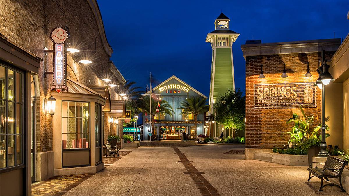 Disney Springs at night in Orlando, with lit-up boardwalk-style storefronts