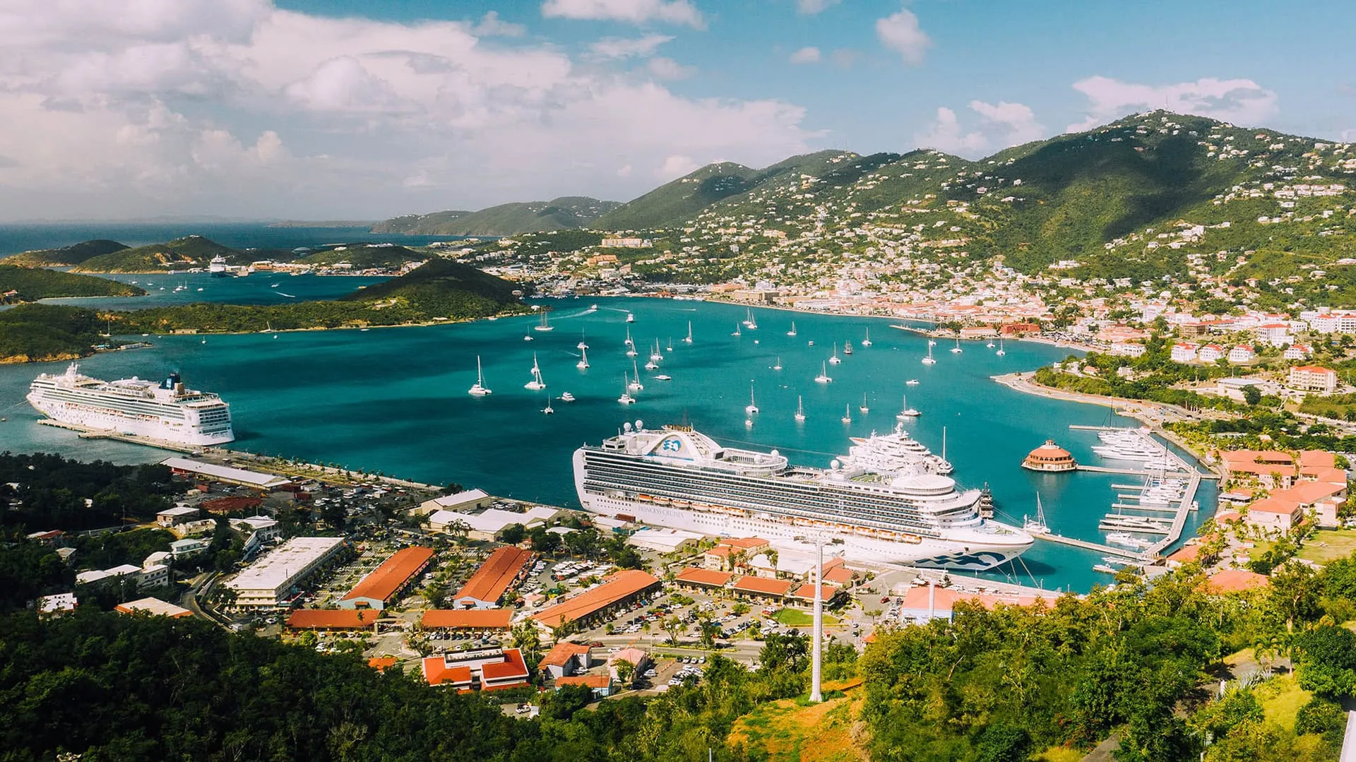 Aerial view of Charlotte Amalie harbor in St. Thomas with cruise ships docked and sailboats anchored