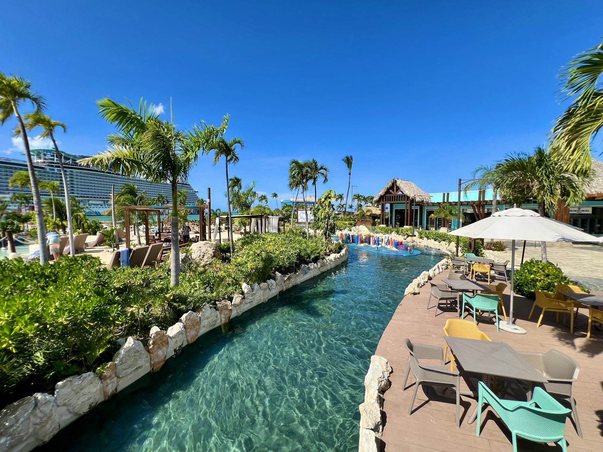 The lazy river and pool deck at Taíno Bay cruise port in Puerto Plata, with a cruise ship docked behind